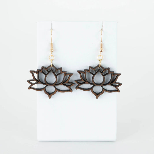 These hypoallergenic Lotus Flower Drop Earrings from Mirabilia Boutique showcase a lotus blossom design with detailed cutouts, gracefully suspended on gold hooks against a simple white backdrop.