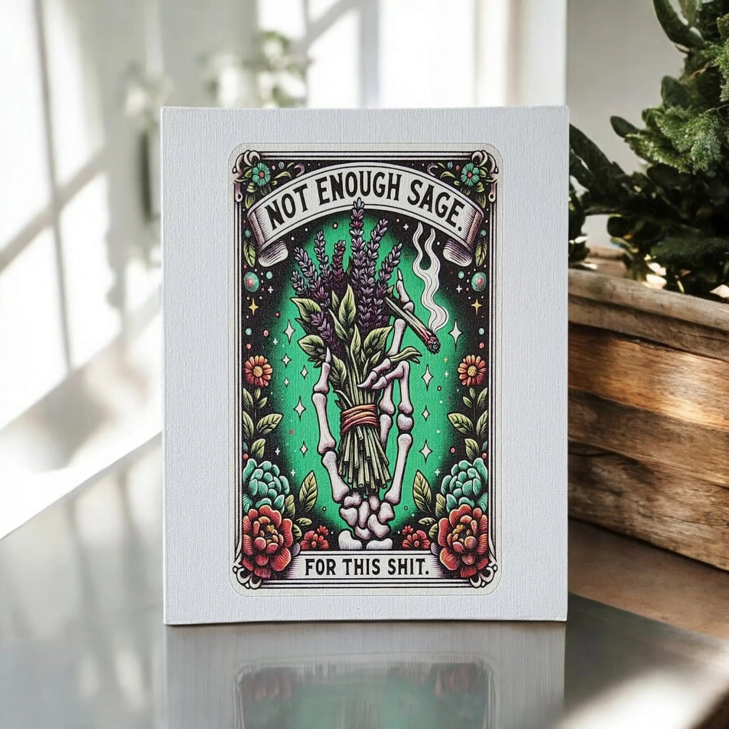 The "Humorous Sage Quote Wall Art Print for Home or Office Decor" by Mirabilia Boutique features a playful design titled "Not Enough Sage for This Shit," depicting a hand holding sage surrounded by bright flowers on a green background. Displayed on a reflective surface with plant accents, this piece makes for an ideal funny gift for any occasion.