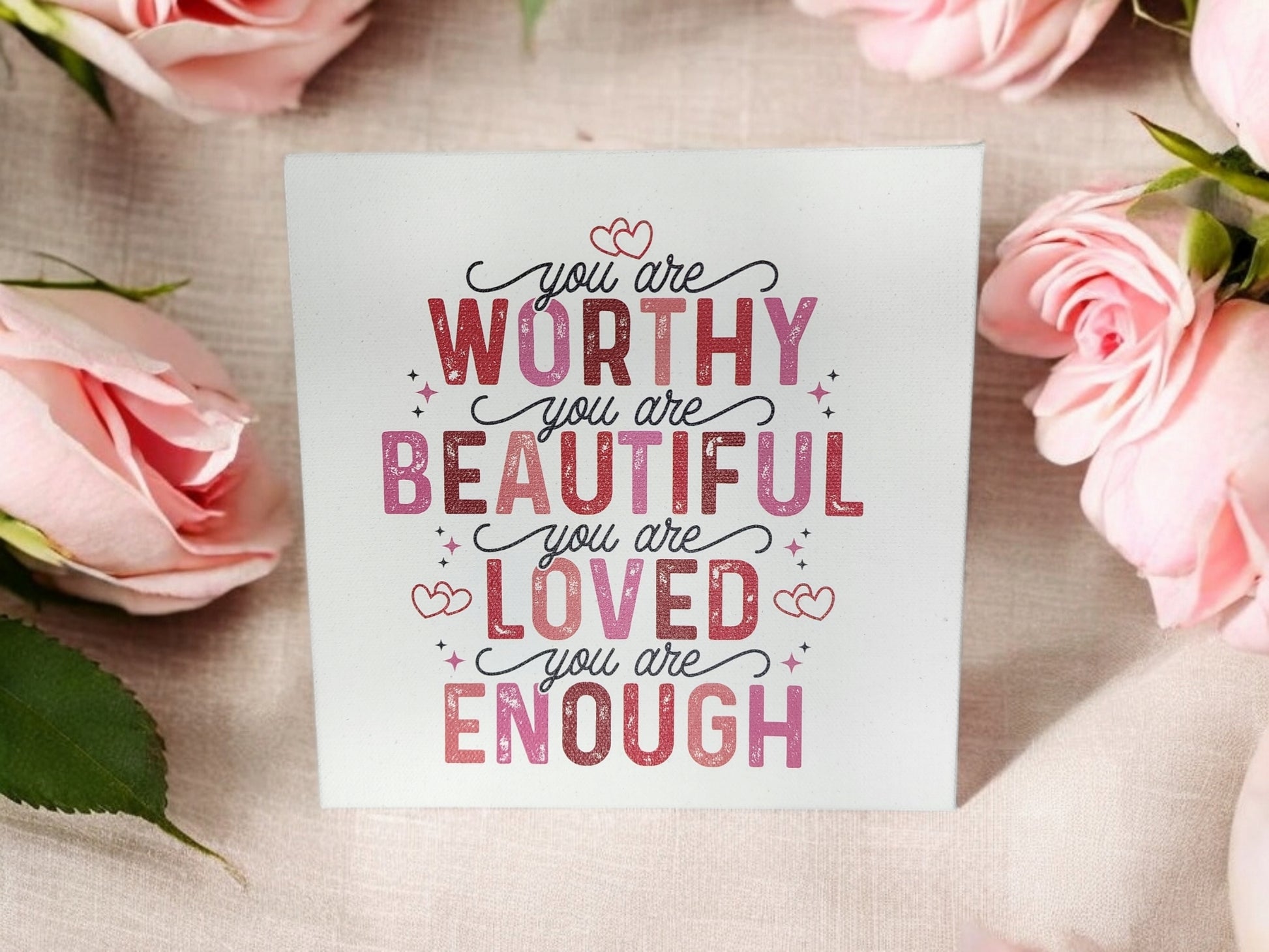 Mirabilia Boutique's "You Are Worthy, Beautiful, Loved, Enough" 8x8 Cradled Canvas Sign features empowering affirmations in pink and red decorative fonts with heart designs, surrounded by pink roses—perfect for uplifting home decor.